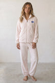 Pyjama femme hiver en pilou écru rosé, veste zippée col chemise à écusson et pantalon assorti, vue de face